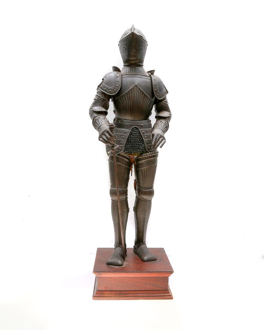 VICTORIAN MINIATURE FULL KNIGHT SUIT OF ARMOR: Copy of the full suit of armor with sword, metal decorated with ribbed design, green velvet under layer, set on a wooden pedestal. Dimensions: H: 27 in., (69 cm.)
