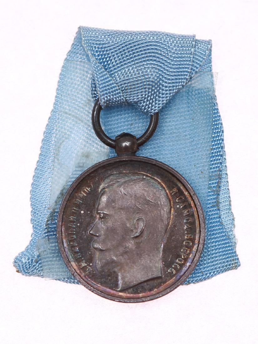 RUSSIAN SILVER MINIATURE MEDAL FOR ZEAL, CA. 1900: The medal with the profile of Russian Emperor Nicholas II with with original ribbon. Unknown maker, ca. 1900-1910. Silver 2.58 g. The medal was established on April 28, 1895. Dimensions: D: 7/16 in., 