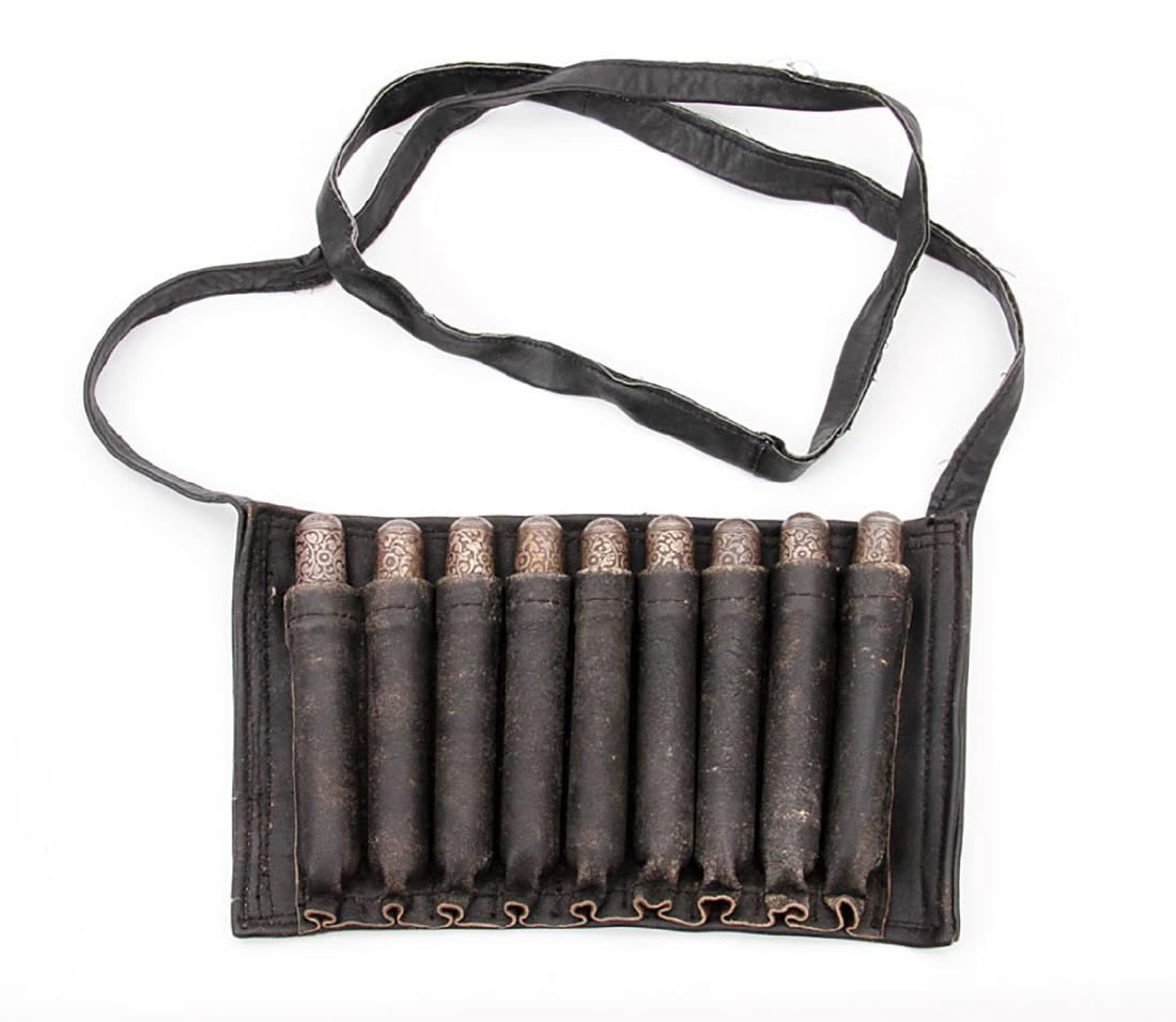 CAUCASIAN BELT CARTRIDGES WITH LEATHER HOLDER: Caucasian leather made cartridge holder with a sling and nine cartridges decorated with silver inlay steel caps. A rare design for Caucasian belt cartridges. Ca. 1900. Dimensions: 9 5/8 x 6 in., (24.5