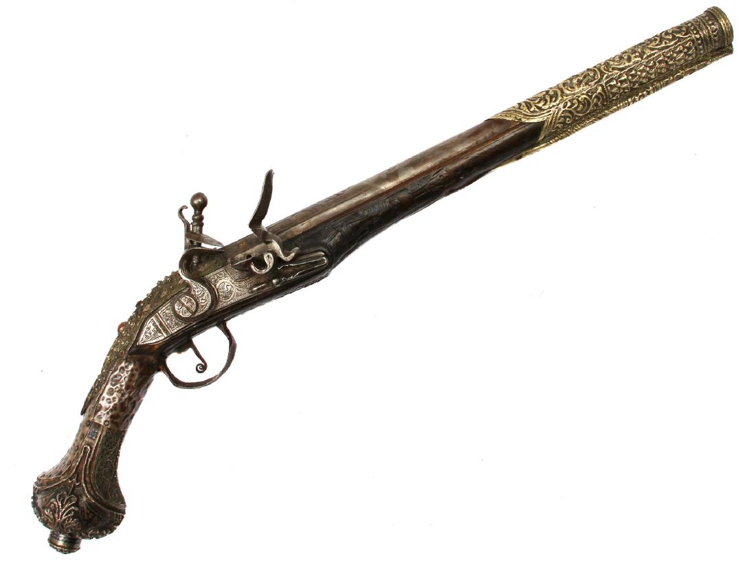 TURKISH OTTOMAN FLINTLOCK PISTOL W. SILVER MOUNTS: Ottoman Empire (Turkish or Balkan) flintlock pistol with silver mounts decorated with filigree work, niello and corals. Long round barrel with chiseled decorations. Barrel features maker's marks. Grip