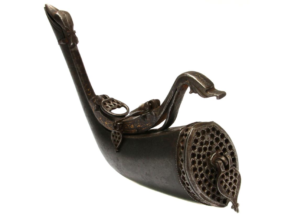 PERSIAN DAMASCUS PIERCED STEEL POWDER FLASK: A Persian gunpowder charging flask entirely made of steel. The upper mount and front made of pierced steel. The body of Damascus steel with two hanging lose loops. Ca. late 18 - early 19th cc. Dimensi