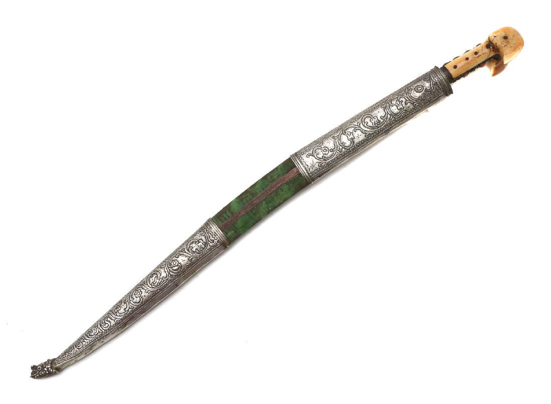 TURKISH ISLAMIC SILVER YATAGAN SWORD, 19TH C.: With characteristic re-curved single-edged blade, handle with walrus scales and decorated with silver rib mounted with corals, wooden scabbard covered with original green velvet, low grade embossed si