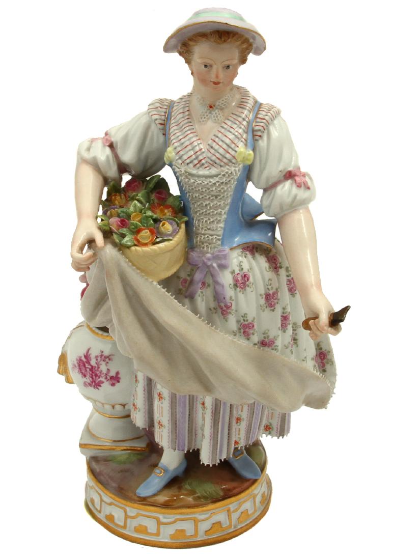 A MEISSEN PORCELAIN FLOWER-GIRL FIGURINE, 19TH C.: A Meissen multi-color porcelain figurine statue of a girl with flowers next to plant vase and flower cutter in her hand. Gold accents throughout statuette.This item is fully marked at the bottom: blue