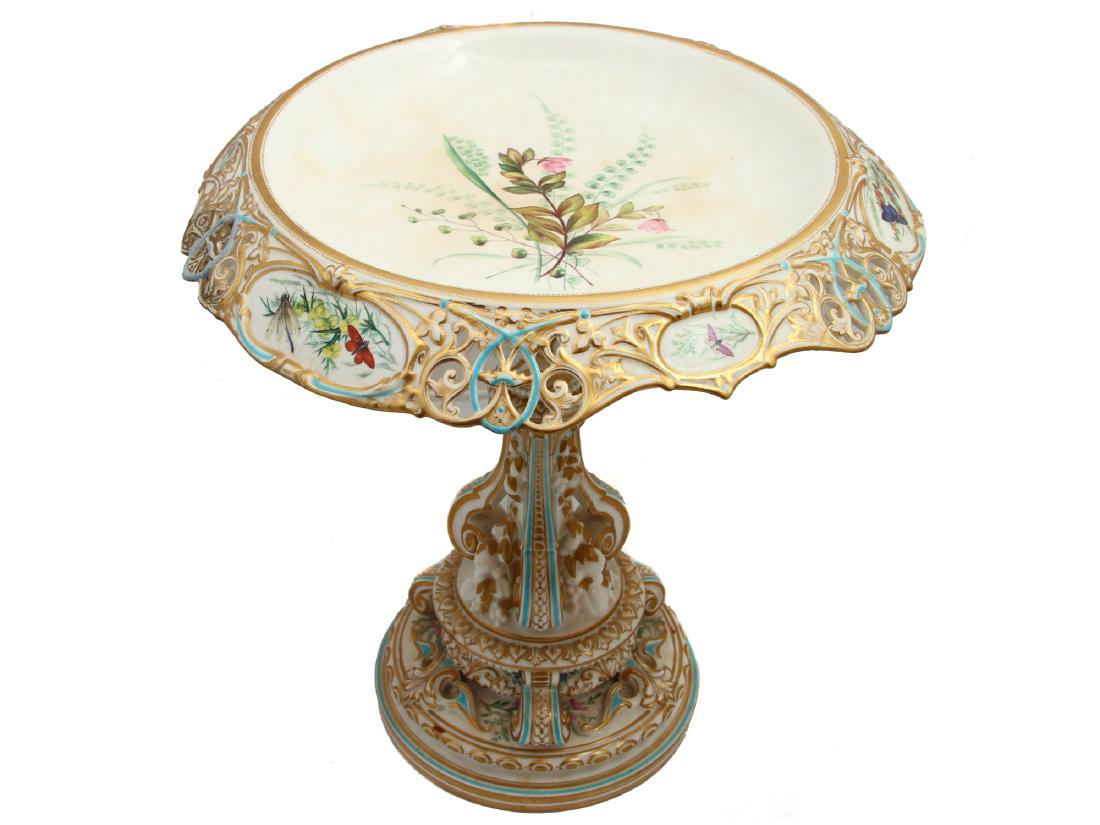 POSSIBLY RUSSIAN HAND PAINTED PORCELAIN COMPOT: Antique pierced porcelain compote cake stand or centerpiece. Hand painted with floral motifs, various insects, butterflies, and gilt highlights. No marks. Dimensions: H: 12 1/2 in., (32 cm.)