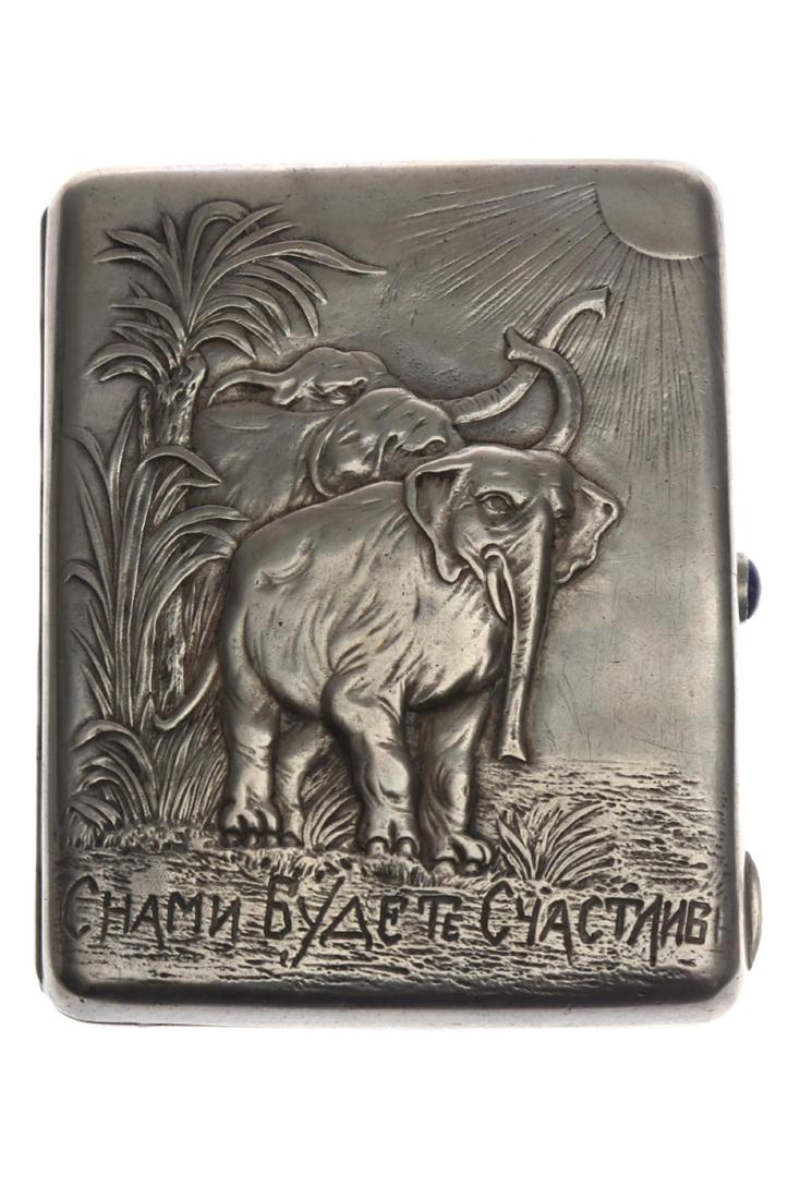 A ART DECO RUSSIAN SILVER GILT CIGARETTE CASE, 19TH C.: Large handcrafted silver gilt cigarette case featuring an elephant with the inscription in Russian "You will be happy with us". Lock adorned with gem stone. Hallmarked "PP" (Petrov, Petr, p. 225, fig.