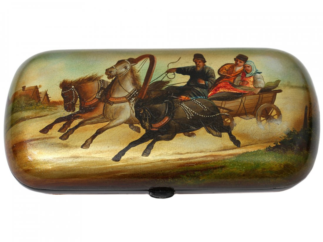 A RUSSIAN LACQUERED BOX PEN HOLDER WITH TROIKA: Handcrafted and painted lacquer box, portraying a family, racing on troika. Paper-mache, tempera and oil lacquer painting with push thumbpiece. Dimensions: 5 1/4 x 2 1/2 x 1 in., (13.4 x 6.3 x 2.5 cm.