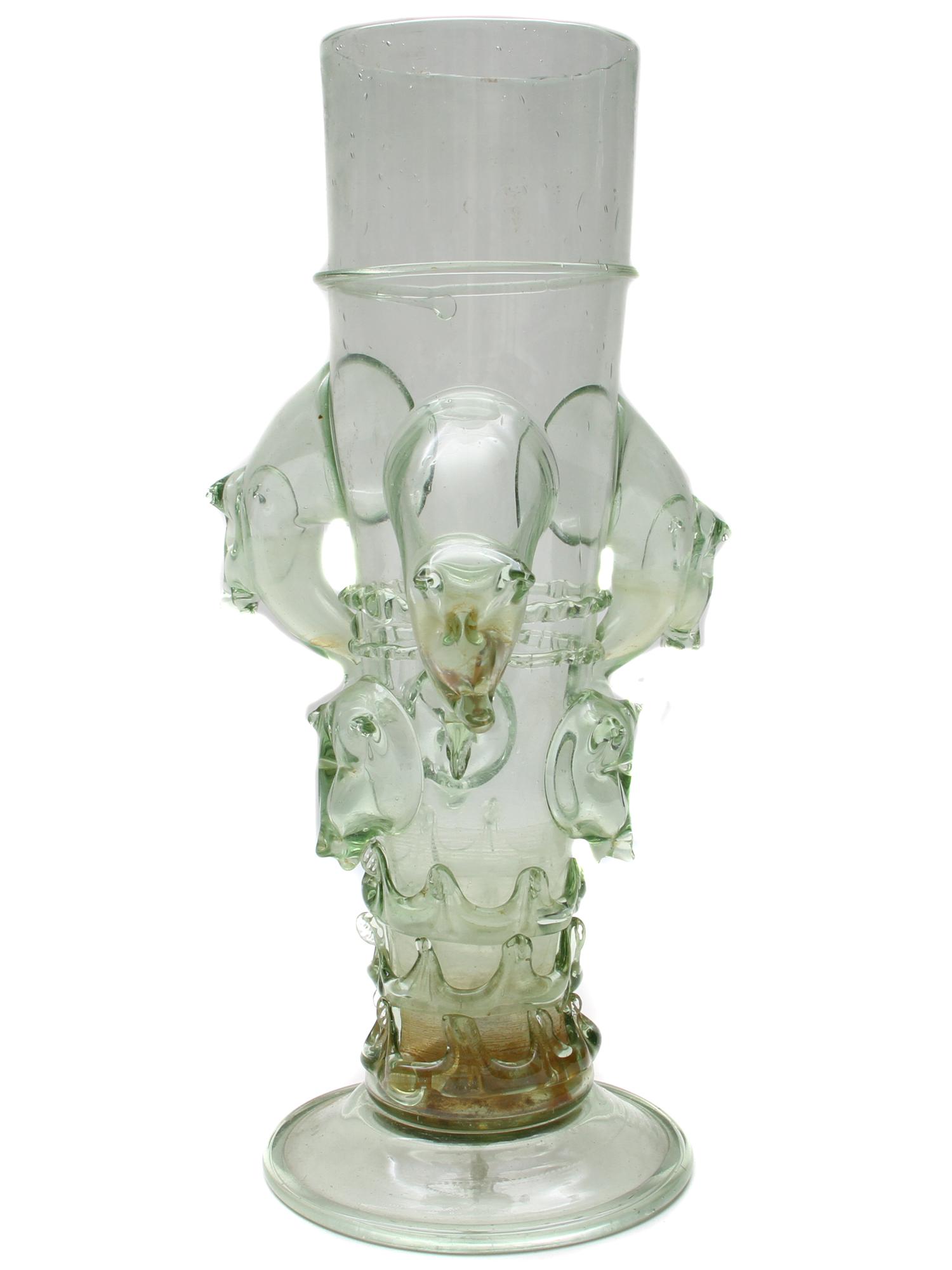 A LARGE GERMAN FOOTED BEAKER 1550-1700: A large German free-blown pale yellow-green glass with applied decoration. This type of glassware was very popular in Germany and the Netherlands in the 16th and 17th centuries. A similar example may 