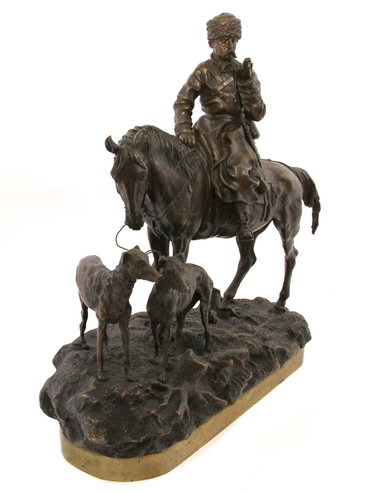 A RUSSIAN BRONZE COMPOSITION DEPICTING COSSACK AT HUNT: Mounted on a base "Return from the hunt" the bronze composition depicts a Russian Cossack returning from a hunt with two dogs.Modeled by V. Y. Grachev (1831-1905), one of the best masters of small pla