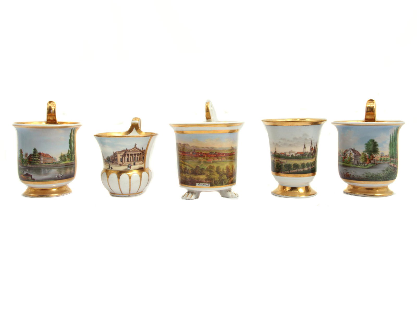 A SET OF FIVE GERMAN PORCELAIN WITH SCENERY 19 C: A set of five antique Biedermeier Period hand-painted German cups. All cups are slightly different in shape, decorated with gilding and various hand-painted landscapes. On the bottom, the cups have bl