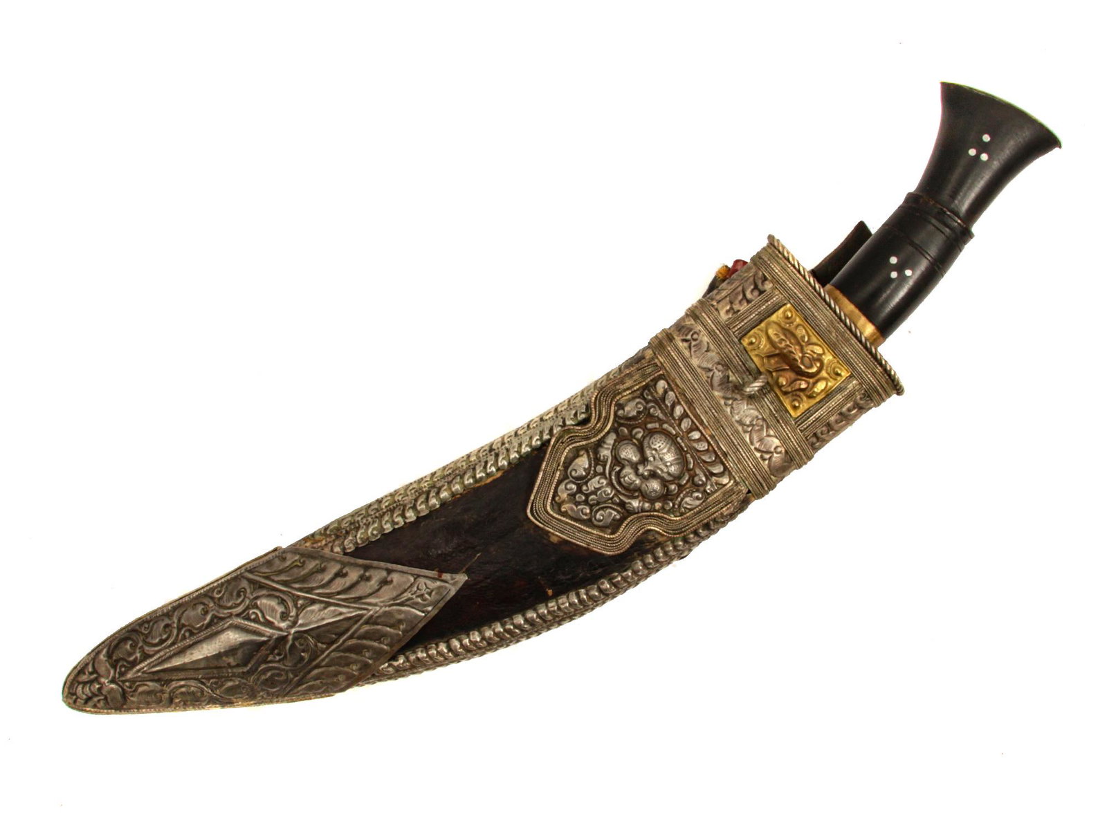 A LARGE NAPALESE KUKRI SILVER-MOUNTED KNIFE: Horn hilt decorated with bone insets and brass ferrule, curved single-edged blade with chiseled decoration, wood leather covered scabbard with embossed silver mounts and gilt embossed plate, two small