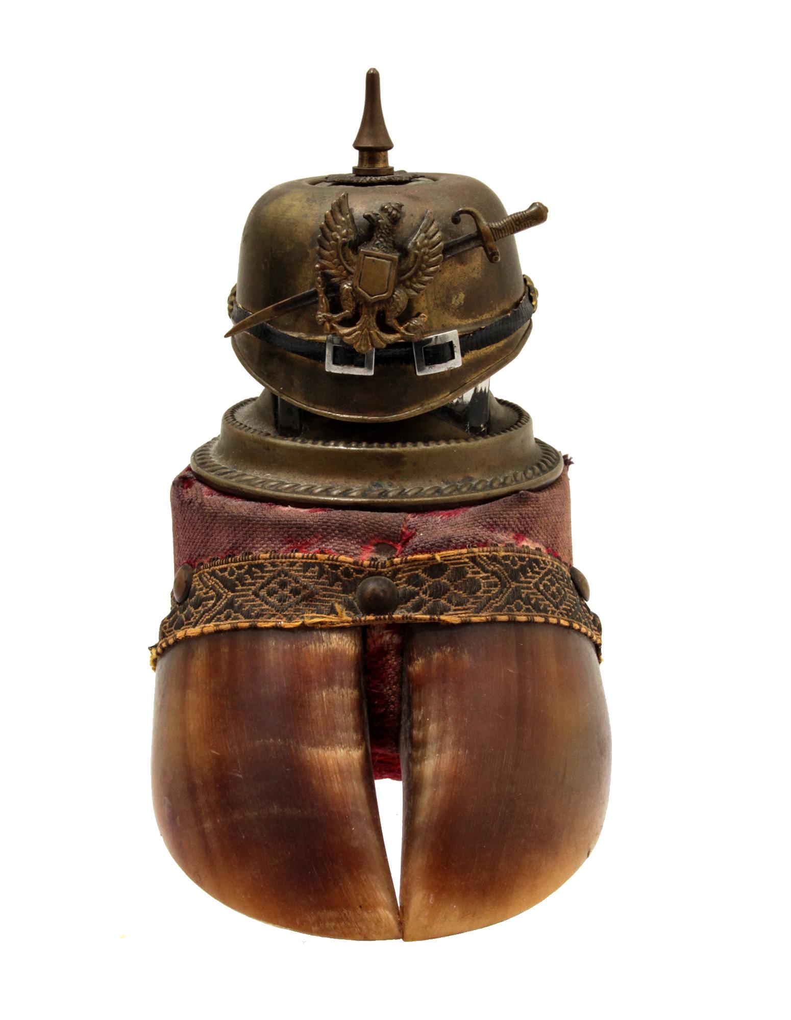 A GERMAN OR POLISH INK WELL WITH PICKELHAUBE, WWI: WWI Military inkwell. Mounted on a boar hoof a glass bronze-mounted inkwell with a lid cast as pickellhelm or pickelhaube with the Polish eagle. The hoof is covered in original red velvet cloth. A WWI