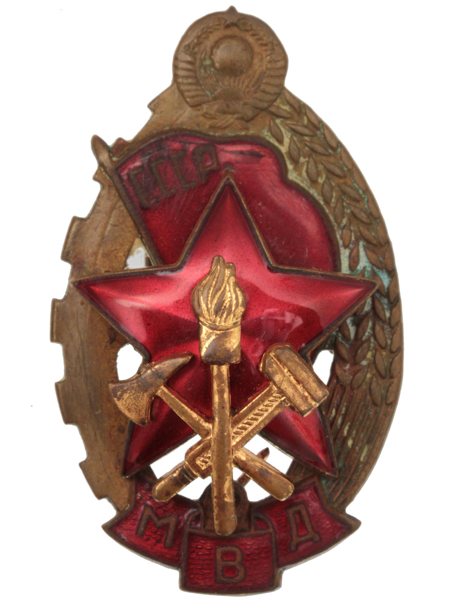 A SOVIET BADGE ISSUED TO THE BEST FIRE FIGHTER: A vintage Soviet badge "To the Best Fire Fighter" of the USSR Ministry of Internal Affairs. Tompac, enamel. The badge is an oval, at the top, there is a symbol of the USSR, the left part of the badge 