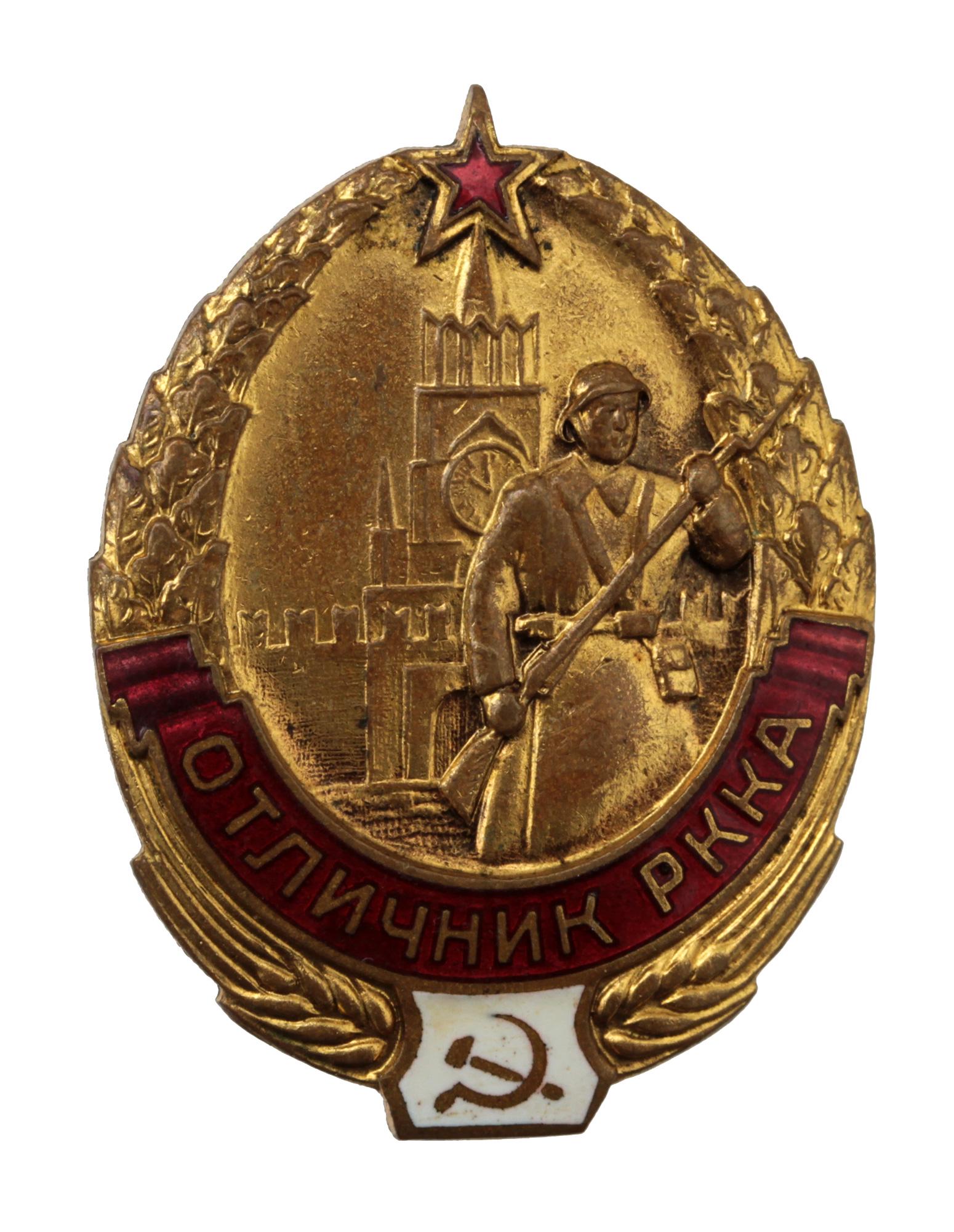 AN ANTIQUE RUSSIAN SOVIET GOLDPLATED BADGE: The oval badge is framed at the bottom with ears of wheat, the upper part of the wreath consists of garlands of oak leaves connected at the top with a red five-pointed star. At the bottom of the badge