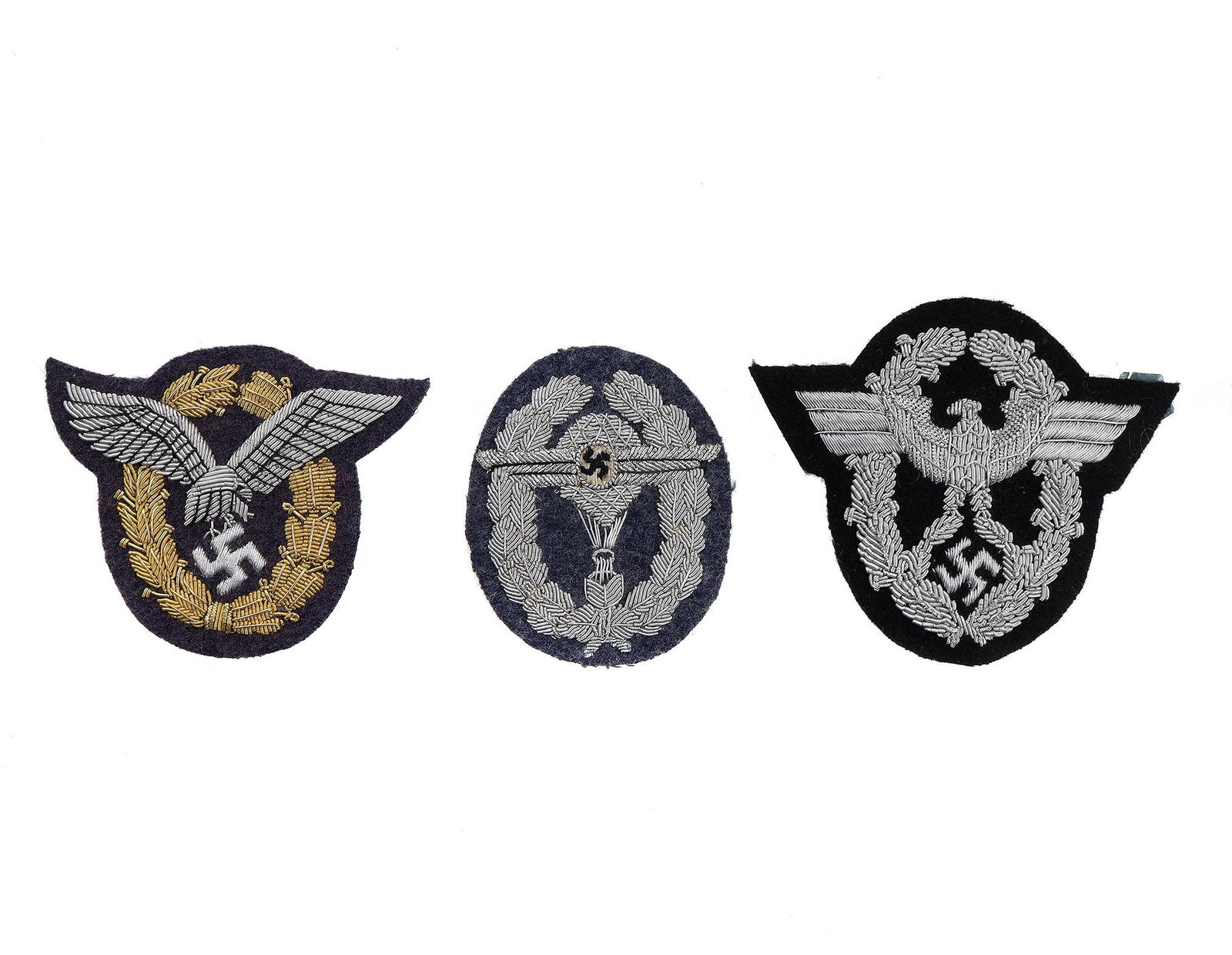 A LOT OF THREE WWII NAZI GERMANY INSIGNIAS: A collection of embroidered German qualification badges: Police officer sleeve insignia with an eagle, embroidered insignia Pilot observer, and a Paratrooper insignia. Dimensions: L: 3 1/2 in., (9 cm.