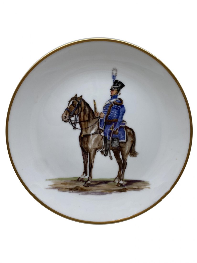 A NYMPHENBURG PORCELAIN PLATE DEPICTING A HUSSAR ON A: A Hans Kratzer painted porcelain plate depicting a mounted hussar of the Napoleonic Wars 1813. The plate is marked on the verso underglaze by the manufacturer and bears the artist's name. Dimensions: