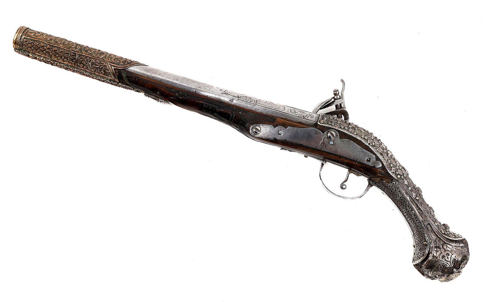 A TURKISH ISLAMIC SILVER MOUNTED FLINTLOCK PISTOL: Ottoman Empire (Turkish or Balkan) flintlock pistol with silver mounts decorated with filigree work and niello. Long round barrel with chiseled decorations. RepoussÃ© band at the front section of th