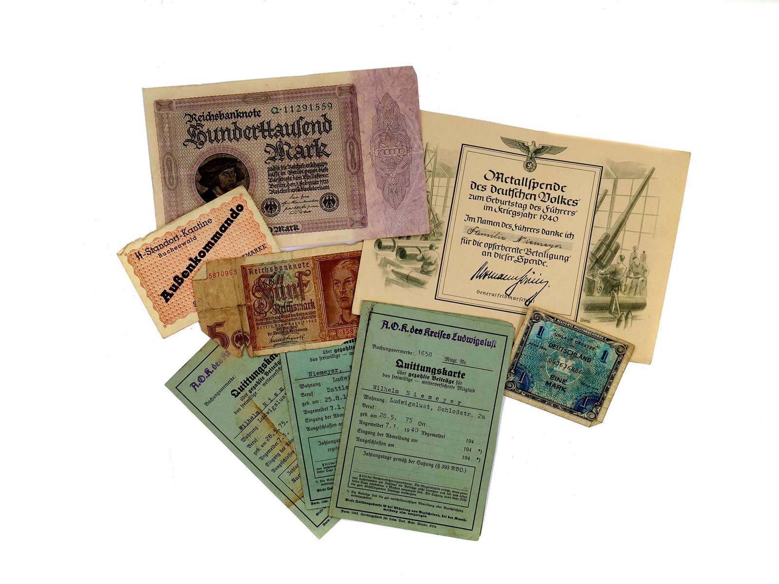 A NAZI GERMAN WWII BANKNOTES AND ORIGINAL DOCUMENTS: The lot includes a standard 5 Reichsmark banknote issued in 1939, a Reichsbank note valued at 100,000 marks and distributed in Germany from February to November 1923, with the front medallion depictin