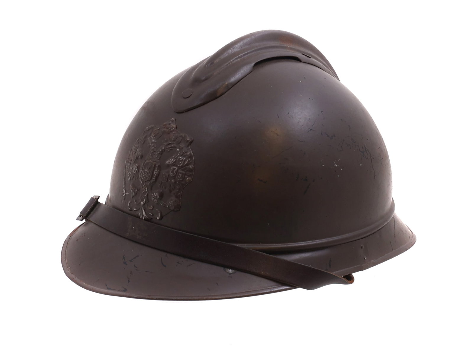 A WW1 RUSSIAN ARMY M15 ADRIAN HELMET: M15 Adrian helmet fit with a Tsarist insignia. This helmet is painted dark brown and is of the version first issued to Russian fronts on the Northern Front. H: 8 in., (20 cm.)