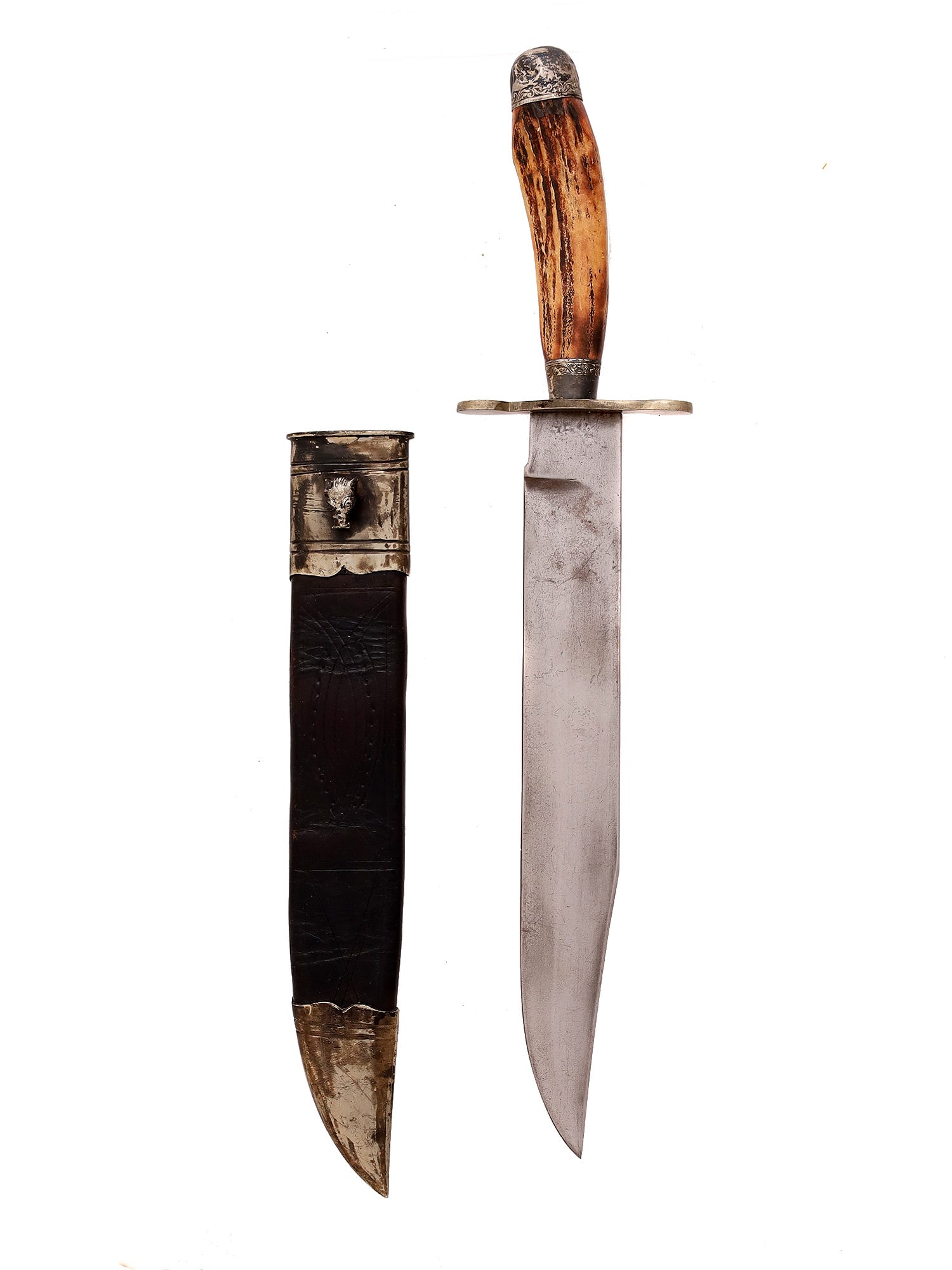 A JAMES RODGERS ROYAL CUTLERY SHEFFIELD BOWIE KNIFE: An antique English bowie or fighting knife with sheath. The knife features a stag handle with sterling silver foliate repousse pommel and bolster (Marked "Sterling" on each). The blade is single-edged