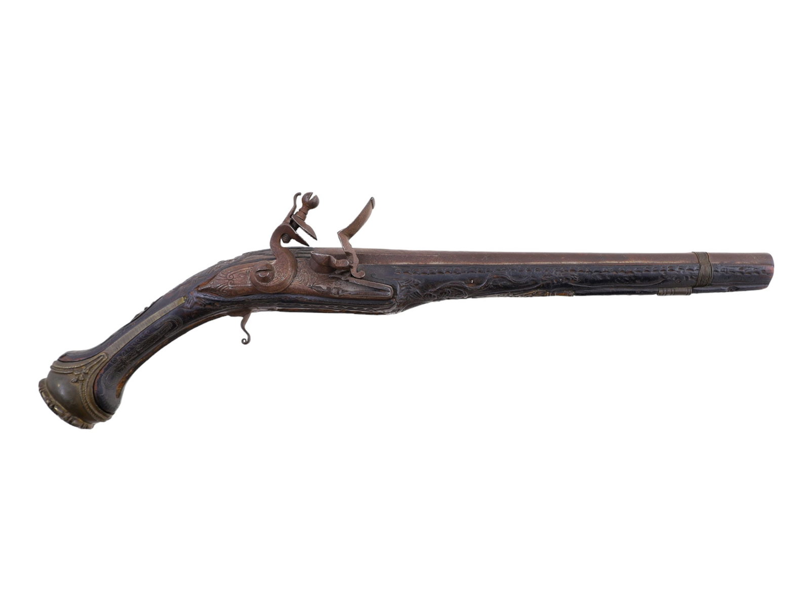 A TURKISH FLINTLOCK PISTOL WITH SILVER INLAY, 19TH CENTURY: A 19th-century Turkish single-shot flintlock pistol with silver inlay and brass mounted. The handle is slightly curved with a brass rounded pommel. The pommel displays a coiled floral motif and is hel