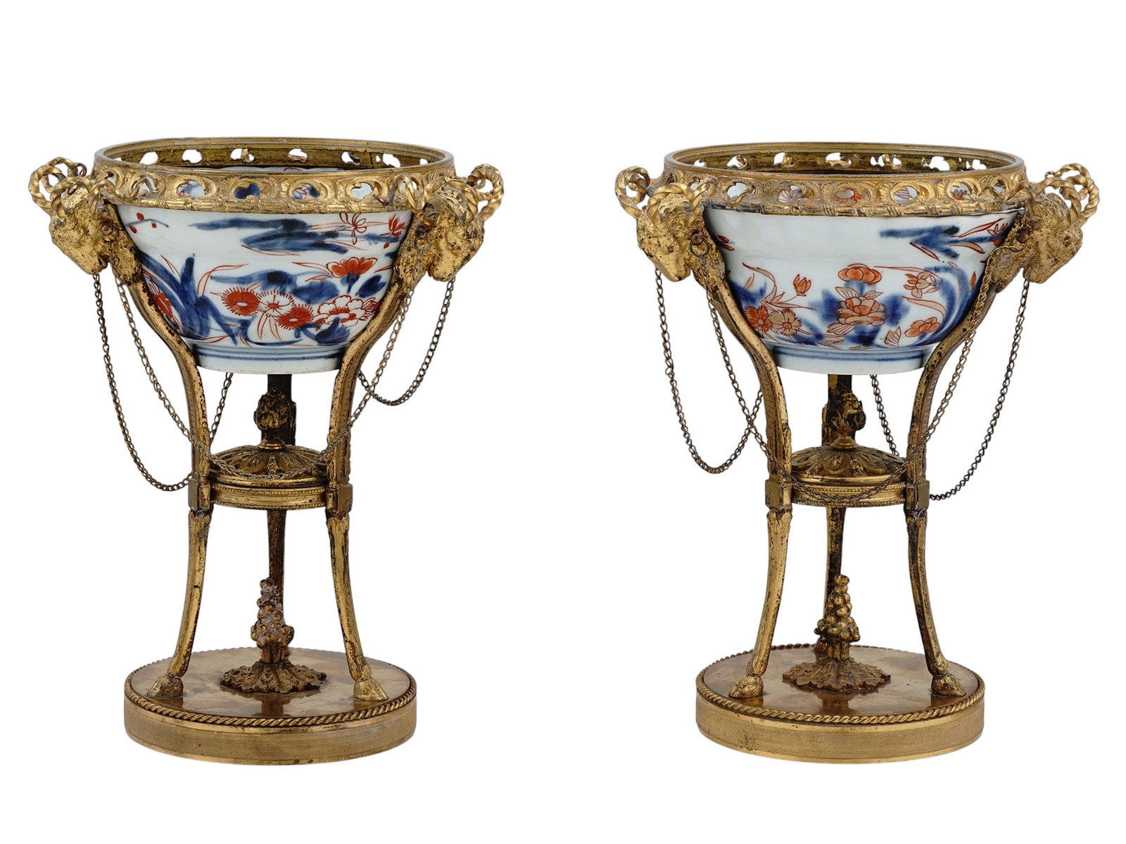 A PAIR OF IMARI PORCELAIN POTPOURRI BOWLS WITH GILT-BRONZE STANDS, 19TH CEN.: A pair of Imari porcelain bowls with floral imagery, set within ormolu bronze stands in Louis XVI style, each stand being hung with chains from sculpted ram's heads. Continental Europe and Japan, earl