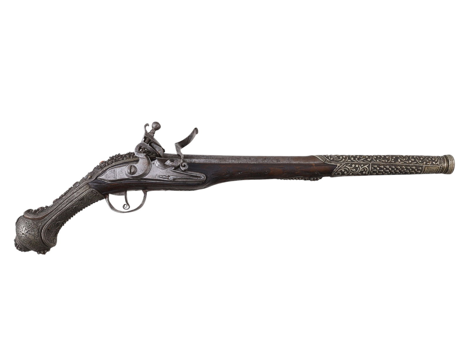 AN OTTOMAN FLINTLOCK PISTOL WITH ORNATE SILVER MOUNTS, 19TH CEN.: An Ottoman flintlock pistol with extremely intricate, ornate silver mounts across much of its surface. The backstrap of the grip is set with four coral cabochons and a square niello medallion. The bar