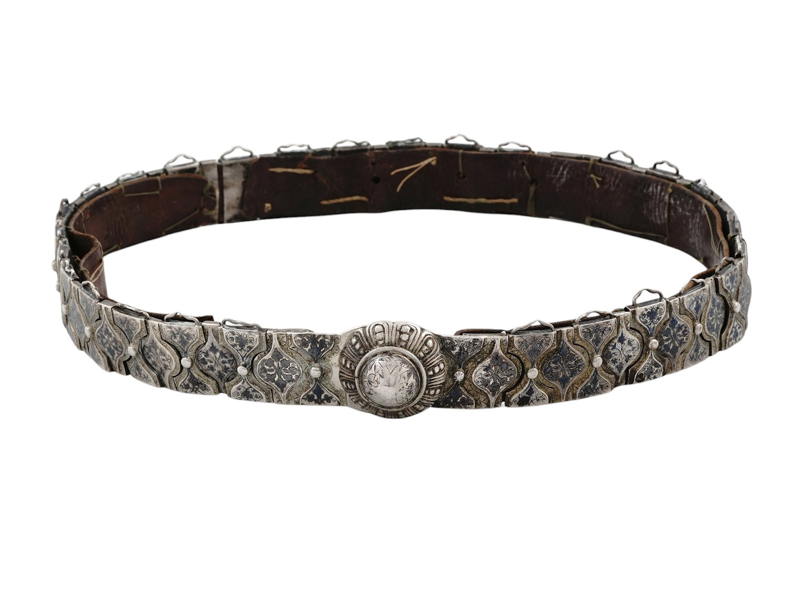 A RUSSIAN SILVER NIELLO CEREMONIAL BELT, 19TH CENTURY: This silver niello belt is made of Russian silver with a leather inner attached with threading. The silver segments act as joints allowing the belt to staghten and fold. Each segment has a hook on the