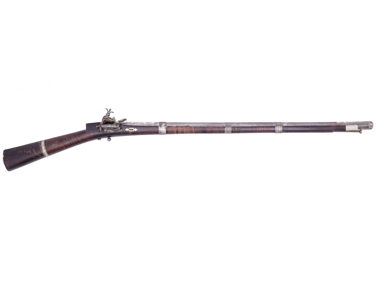 AN OTTOMAN TRANSCAUCASIAN FLINTLOCK RIFLE WITH SILVER INLAY, 18TH CENTURY: A Transcaucasian flintlock rifle of the Ottoman Empire with an exquisitely patterned Damascus steel barrel and intricately chased and molded silver barrel bands. The breech, tang, and muzzle are all o