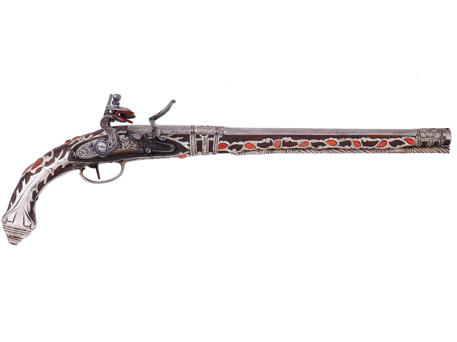 A CORAL SET SILVER-MOUNTED ALGERIAN FLINTLOCK PISTOL, 19TH CENTURY: An early 19th century Ottoman Algerian flintlock pistol, with a long steel barrel affixed with two pierced and chased silver bands with foliate patterning. The wood stock being inlaid with similarly c