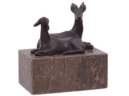 A RENEE SINTENIS BRONZE SCULPTURE OF TWO GAZELLES, GERMAN, 1930: A bronze sculpture by Renee Sintenis features two stylized reclining gazelles or antelopes, cast in a simplified, modernist form. They are mounted on a rectangular marble base, which adds a refined an