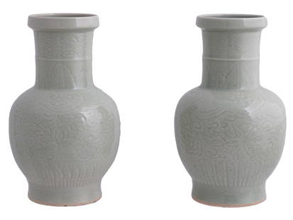 A PAIR OF CHINESE CELADON GLAZED PORCELAIN VASES, C. 1920: A pair of matched Chinese celadon glazed vases, of a baluster form, fluidly carved with underglaze decoration of flowers and leaves. Both have a blue ink Yongzheng six-character mark on the bottom and