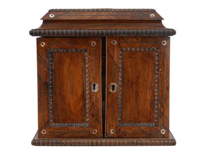 AN ENGLISH JEWELRY CABINET, 19TH CENTURY: An English jewelry cabinet, 19th century, of upright rectangular form, finely crafted in richly figured rosewood with applied gadrooned molding to the base and lid, and inset with mother-of-pearl roun