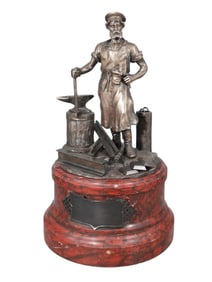 A LARGE LATE 19TH CENTURY RUSSIAN PARCEL-GILT SILVER FIGURE OF A BLACKSMITH ON RED MARBLE BASE,