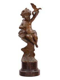 A BRONZE FIGURE OF A PUTTO ON A ROUND BASE