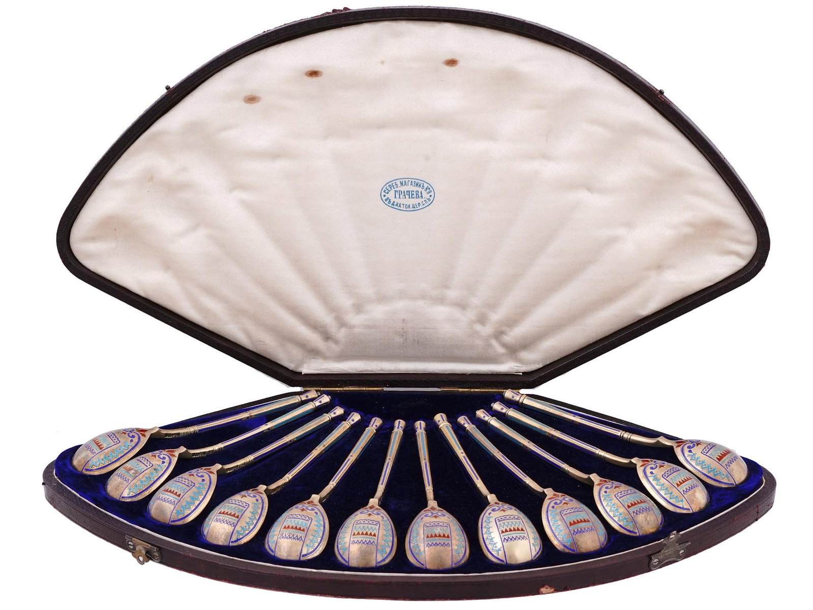 RUSSIAN SET OF 12 SILVER AND ENAMEL SPOONS, 1884: A SET OF TWELVE RUSSIAN SILVER-GILT AND CHAMPLEVE ENAMEL SPOONS St. Petersburg, 1884. Retailed by Grachev. The back of the bowls decorated with a traditional Pan-Slavic ornament. Contained in original