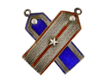A RUSSIAN SILVER AND ENAMEL BADGE IN THE FORM OF A CROSSED SHOULDER BOARDS