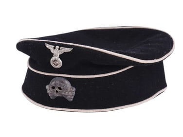 AN EARLY BRIMLESS SS CAP WITH TOTENKOPF BADGE, DATED 1934, GERMANY