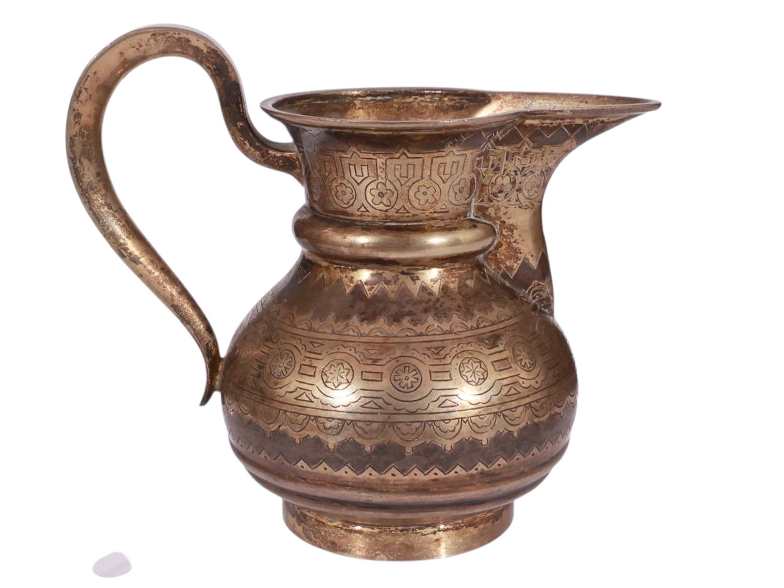 A RUSSIAN ENGRAVED SILVER PAN-SLAVIC STYLE CREAMER: Of bulbous baluster form with a flared neck and pronounced pouring lip, the surface richly engraved with Pan-Slavic geometric ornament, rosettes, and zig-zag borders. The handle of a tapering scroll f