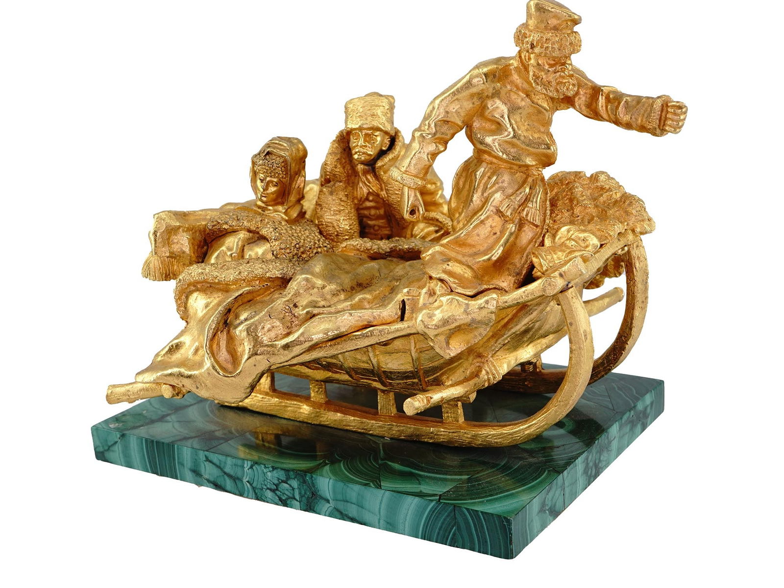 A RUSSIAN GILT BRONZE AND MALACHITE FIGURAL GROUPING, 19 C.: A Russian gilt-bronze on malachite plinth grouping. The sculpture depicts a couple covered in blankets on a sleigh with the driver in traditional Russian costume after the model by Vasily Grachev, Rus