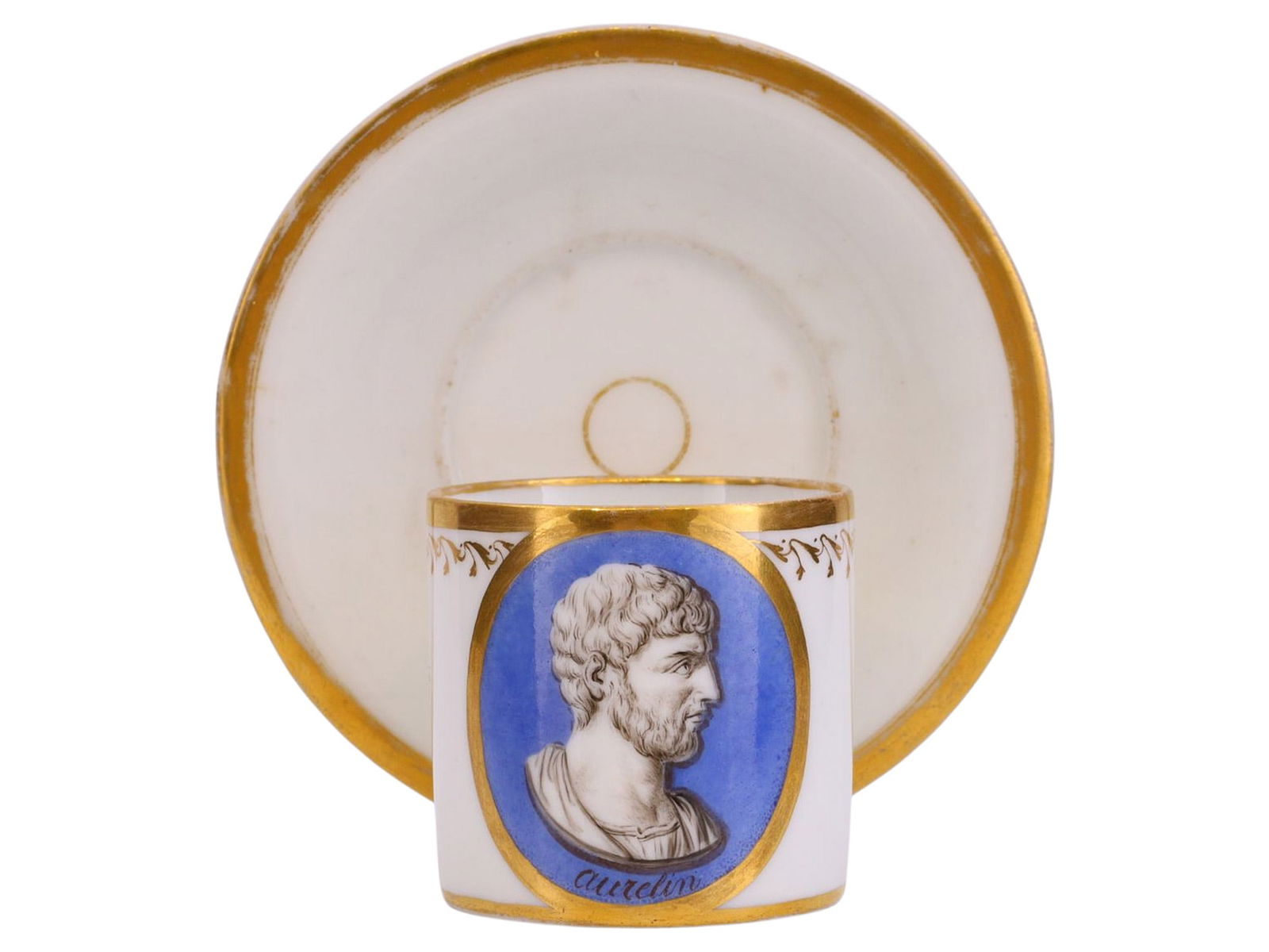 A FRENCH PORCELAIN CUP AND SAUCER WITH CLASSICAL PORTRAIT MEDALLION, FRANCE, EARLY 19TH CENTURY: The cylindrical porcelain cup, finely decorated with a hand-painted classical profile portrait identified beneath as "aurelian", after antique Roman intaglio or engraved gem sources, the bust shown in