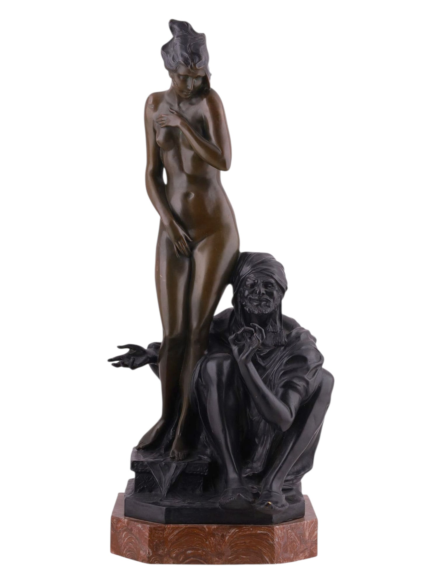 A BRUNO ZACH (AUSTRIAN, 1891–1945) BRONZE FIGURAL GROUP “THE SLAVE SELLER: A striking Art Deco period bronze group by Bruno Zach, depicting a nude female figure standing shyly with one hand across her chest, while an older male merchant or “slave seller” crouches bes
