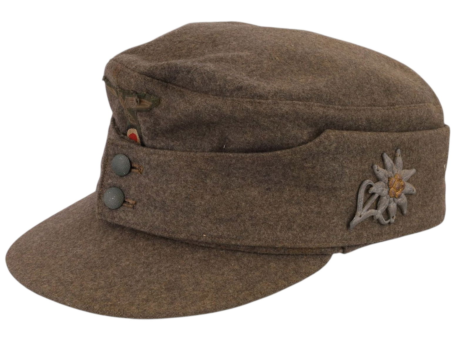 A GERMAN WWII HEER M43 MOUNTAIN TROOPS FIELD CAP WITH EDELWEISS BADGE, CIRCA 1943–1944: Field-gray wool M43 Einheitsfeldmütze issued to Wehrmacht Gebirgsjäger mountain troops. The cap is of standard construction with a short forward visor, fold-down side and rear panels secured at the