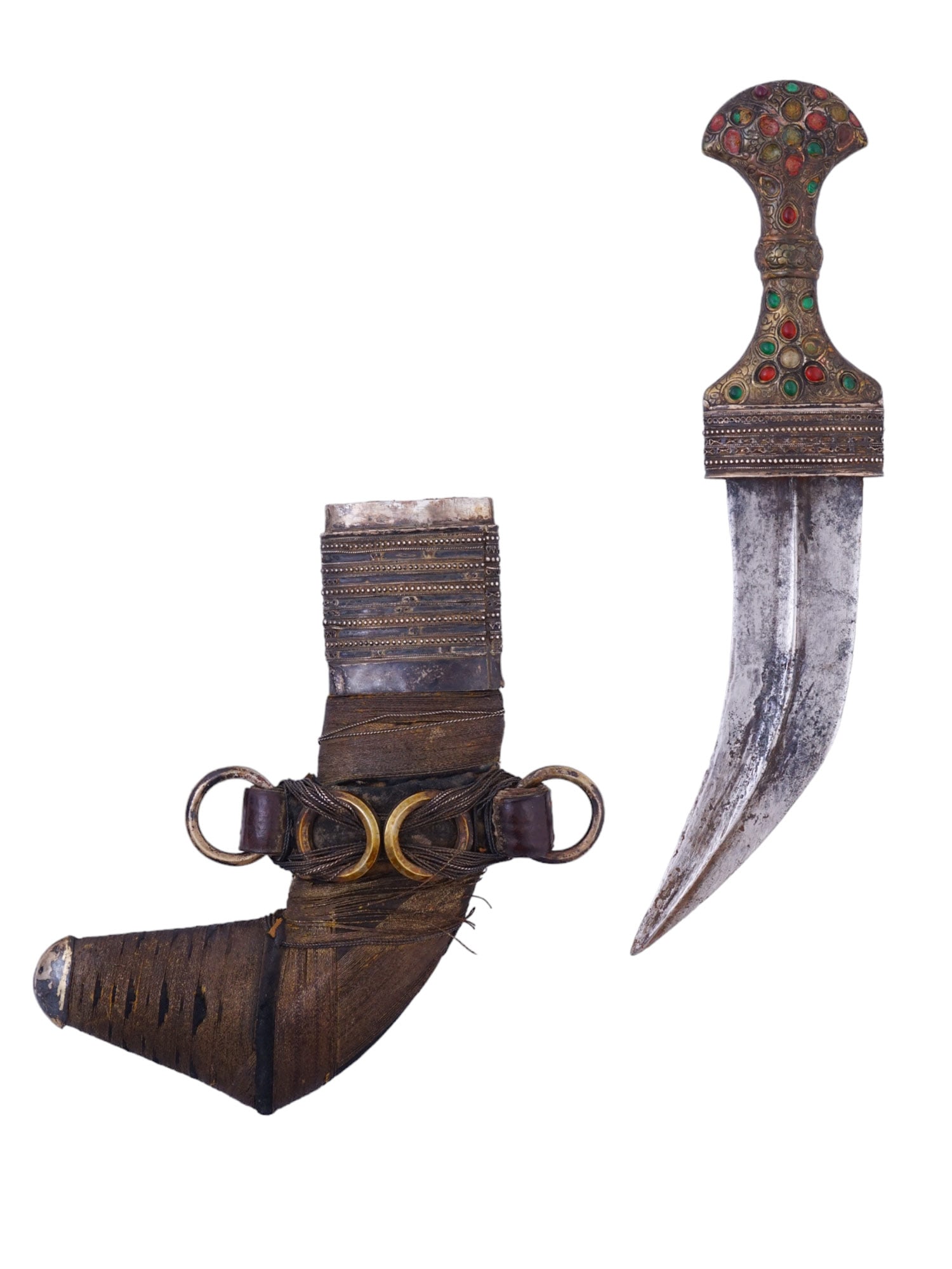 A SILVER-MOUNTED JAMBIYA DAGGER WITH STUDS, 19TH CENTURY: With a curved double-edged blade with a strong medial ridge and tapering point. The hilt of traditional T-shaped form, heavily mounted in silver and profusely set with colored glass or cabochon stones