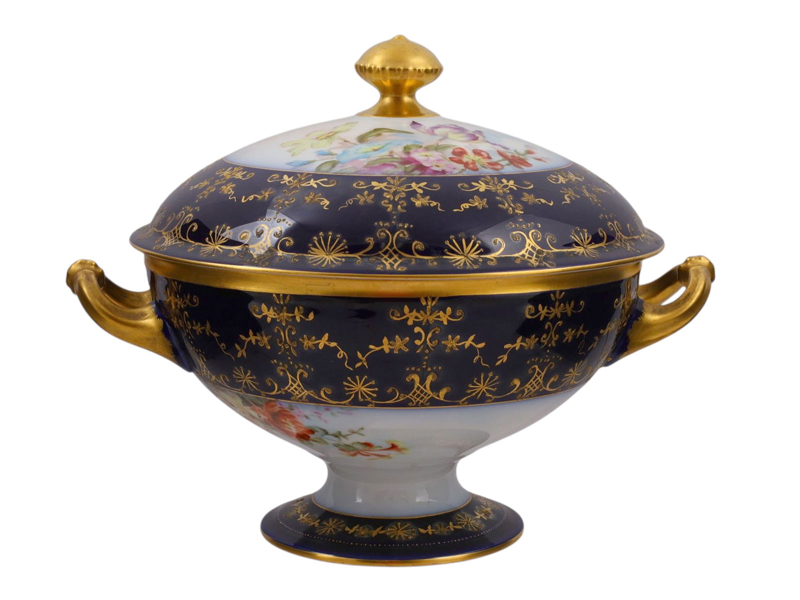 A LIMOGES PORCELAIN COBALT-BLUE AND GILT LIDDED CASSEROLE, LATE 19TH–EARLY 20TH CENTURY: Of circular pedestal form with twin scroll handles and domed cover topped by a gilt finial, finely hand-painted with floral sprays in vivid polychrome enamels on a white ground, framed by deep cobalt