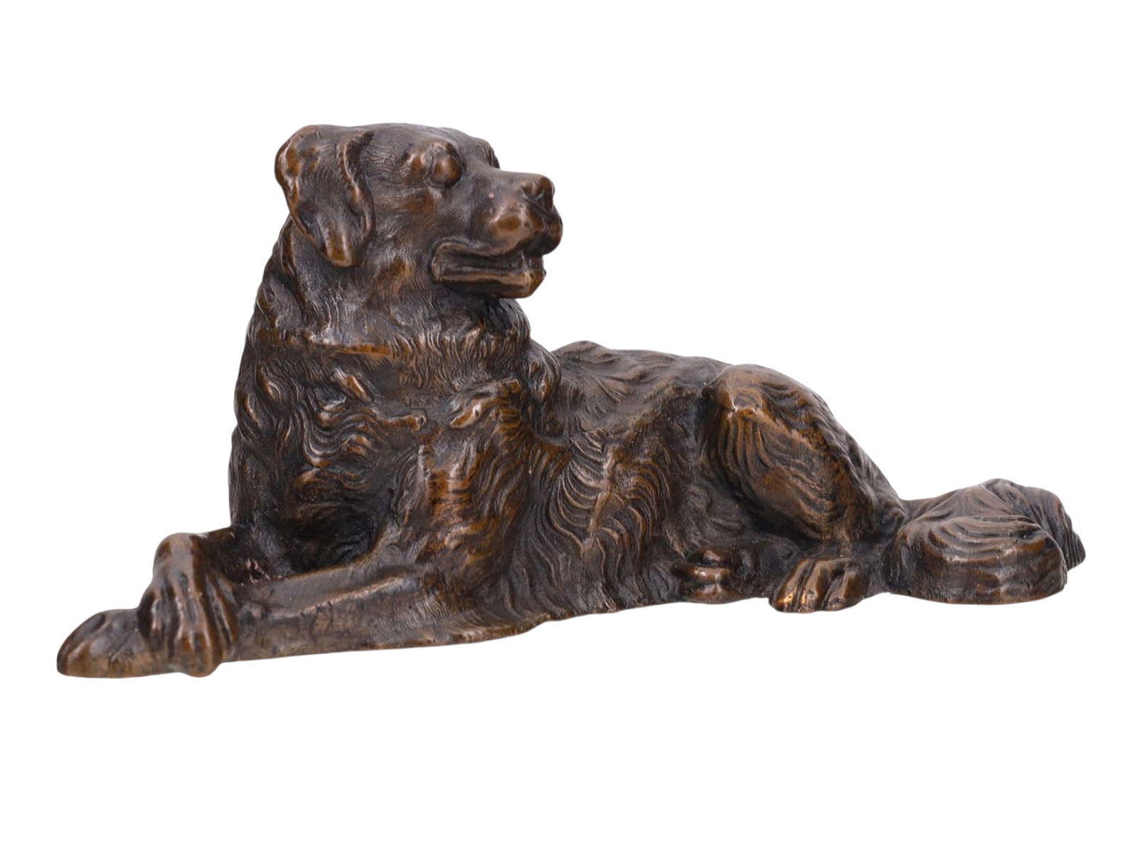 A CONTINENTAL BRONZE OF A RECUMBENT DOG, LATE 19TH–EARLY 20TH CENTURY: A finely cast and naturalistically modeled Continental bronze sculpture of a reclining dog, likely a retriever or spaniel type, depicted with detailed fur texture and a relaxed pose. The animal lies w