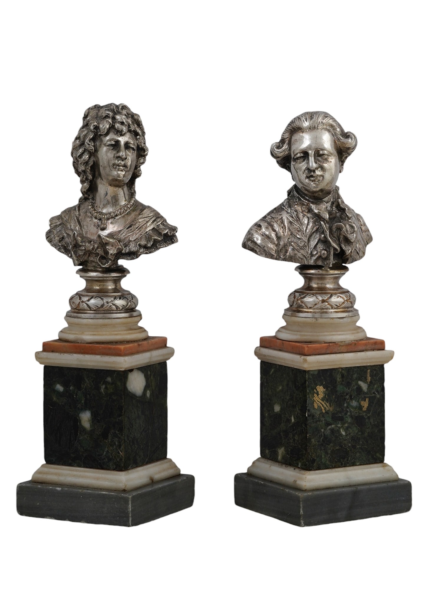 A PAIR OF SOLID SILVER BUSTS ON MARBLE BASES, EARLY 20TH CEN.: European solid silver busts of ancien regime courtiers. Raised on white, rouge and green marble socles. The woman is possibly from the reign of Louis XIV, depicted with curly hair and pearl necklace a