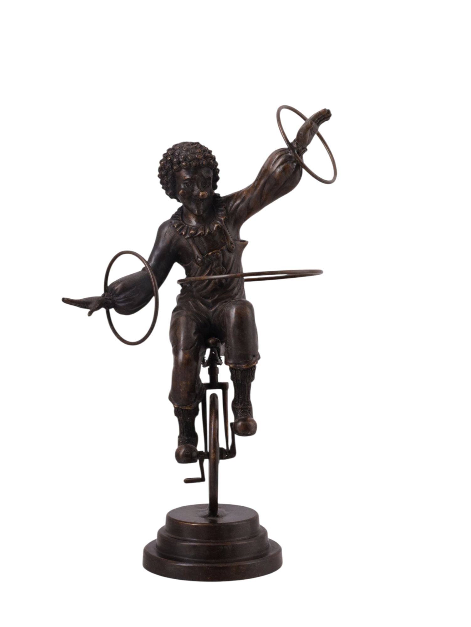 A BRONZE FIGURE OF A CLOWN ON A UNICYCLE, EARLY 20TH CENTURY: Cast in dark patinated bronze, the whimsical figure is modeled as a circus clown with curly hair and a bulbous nose, wearing a ruffled costume and balancing on a unicycle. Both arms extended, holding