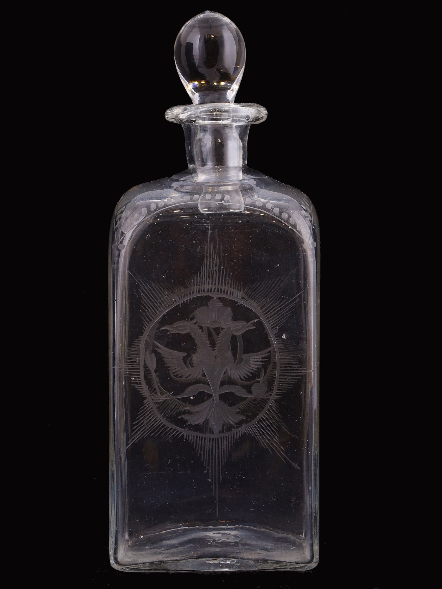 A RUSSIAN IMPERIAL ENGRAVED GLASS DECANTER WITH THE CIPHER OF EMPRESS CATHERINE II, RUSSIA, LAST: Of rectangular form with rounded shoulders and a short cylindrical neck. The front is engraved with the imperial cipher of Empress Catherine the Second, composed of intertwined Cyrillic initials benea