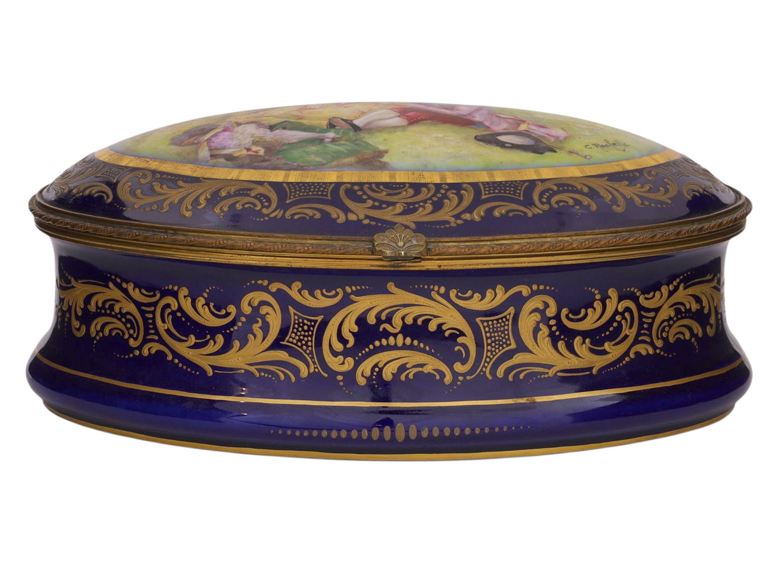 A COBALT-GROUND PORCELAIN LIDDED OVAL BOX WITH HAND-PAINTED RESERVE SEVRES-STYLE, MID 20TH CENTURY: A finely executed Sevres-style porcelain oval box of elongated form, the exterior richly decorated in a deep cobalt-blue ground highlighted with elaborate gilt scrolling foliate ornament in the Rococo
