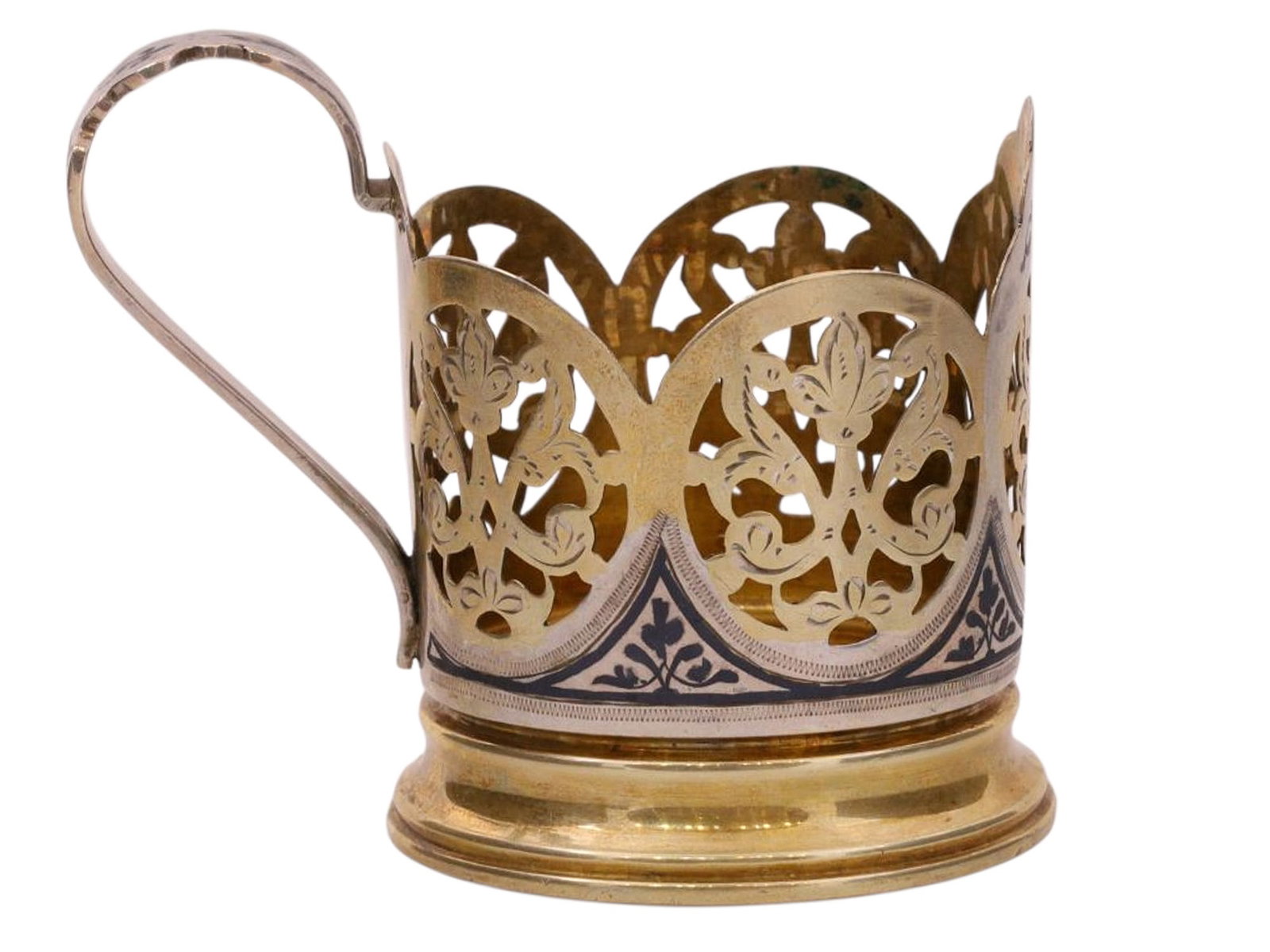 A SOVIET RUSSIAN PARCEL-GILT SILVER AND NIELLO TEA GLASS HOLDER: A Russian parcel-gilt silver and niello tea glass holder with openwork foliate designs.Hallmarks: 'GN' mark, Soviet star with 84 silver proof.Weight: 3.2 oz., (92 g.) Dimensions: H: 3 3/8 in., (8.6 cm